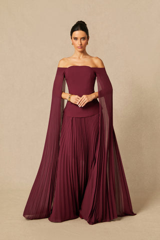 Model wearing burgundy off-shoulder two-piece formal set with pleated chiffon cape sleeves and maxi skirt Burgundy Winter Winered