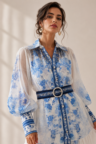 White and blue floral midi dress featuring a porcelain-inspired print, sheer long balloon sleeves, button-front design, matching waist belt, flowing tiered skirt, and integrated inner slip dress, perfect for wedding guests, vacations, garden parties, baby showers, and elegant summer occasions. Amalfi Capri Style Dress eueropean Summer Dress Dolce Gabbana inspired Style Dress