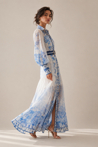 White and blue floral midi dress featuring a porcelain-inspired print, sheer long balloon sleeves, button-front design, matching waist belt, flowing tiered skirt, and integrated inner slip dress, perfect for wedding guests, vacations, garden parties, baby showers, and elegant summer occasions. Amalfi Capri Style Dress eueropean Summer Dress Dolce Gabbana inspired Style Dress