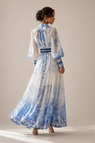 White and blue floral midi dress featuring a porcelain-inspired print, sheer long balloon sleeves, button-front design, matching waist belt, flowing tiered skirt, and integrated inner slip dress, perfect for wedding guests, vacations, garden parties, baby showers, and elegant summer occasions. Amalfi Capri Style Dress eueropean Summer Dress Dolce Gabbana inspired Style Dress