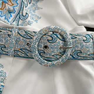 Patterned belt with a buckle on a white fabric background