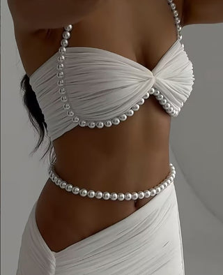 White bikini top with pearl embellishments on a neutral background