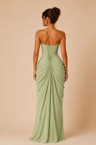 Woman wearing a strapless green gown with a draped design on a beige background