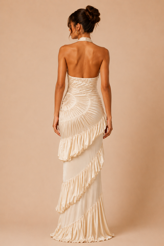 Woman wearing a strapless, ruffled evening gown on a beige background