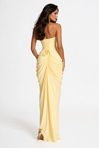 Woman wearing a yellow strapless gown on a white background