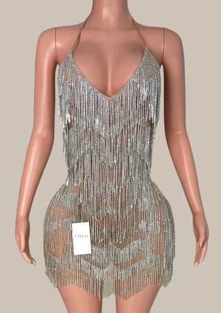 Beaded dress on a mannequin with a beige background tassel fringe rhinestone glitter silver dress 
