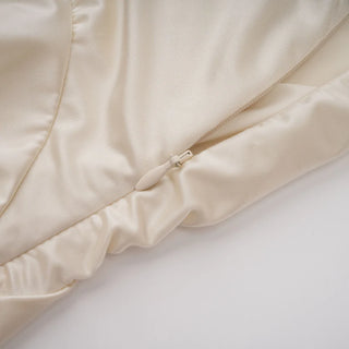 Close-up of a beige quilted coverlet on a white background