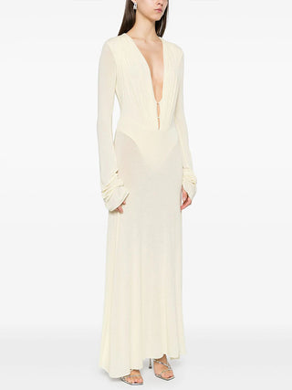 Woman wearing a long, light-colored dress on a white background