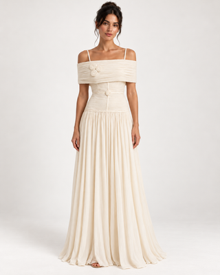 An off-the-shoulder cream maxi dress with a structured corset-style bodice and a flowing skirt, shown on a model against a light gray studio background.