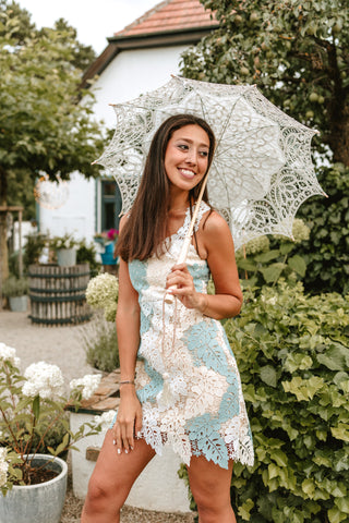 Model wearing a soft blue and ivory mini lace dress with a floral overlay, perfect for summer parties and elegant events by Cielie.