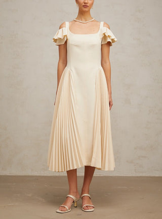 Woman wearing a neutral pleated midi dress with flutter sleeves and darted bodice, ideal for elegant summer events, wedding guest looks, or garden parties.