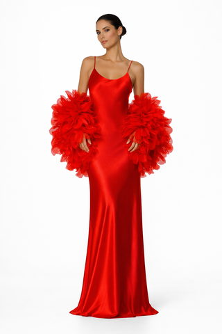 Woman wearing a red evening gown with floral embellishments on a white background
