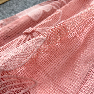Close-up of pink textured fabric with a bow detail