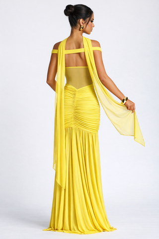 Woman wearing a yellow saree with a plain background