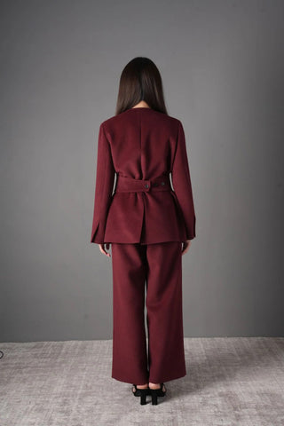 Model wearing the burgundy wool blazer and pants set, styled for a chic professional look with a black chain strap bag.