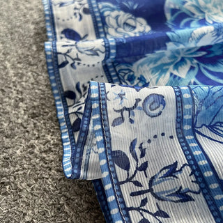 Blue and white floral patterned fabric on a textured surface