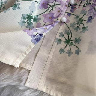 Romantic floral mini dress featuring a watercolor floral print in pink, lavender, lilac, and ivory tones, high neckline, long sleeves, matching waist belt, fit and flare silhouette, and flowing lightweight fabric, perfect for wedding guests, baby showers, bridal showers, garden parties, brunches, and elegant spring or summer occasions.