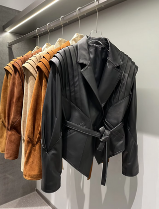 Premium wild leather goatskin suede jackets with pleated shoulder detailing, available in tan, rust brown, beige, and black, hanging on a clothing rack with adjustable belted waists for a tailored fit. Drejani Leather Jacket Suede, Wildleather Jacket