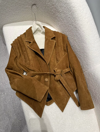 Premium wild leather goatskin suede jackets with pleated shoulder detailing, available in tan, rust brown, beige, and black, hanging on a clothing rack with adjustable belted waists for a tailored fit. Drejani Leather Jacket Suede, Wildleather Jacket