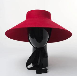 Red wide-brimmed hat on a black mannequin against a white background