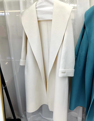 Elegant white cashmere wool coat with a belted waist and large lapel, showcasing its double-sided design. Max MaraCoat similar dupe