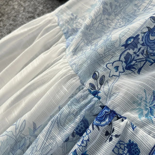 Close-up of white fabric with blue floral patterns on a textured surface.
