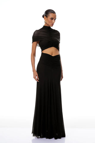 Woman wearing a black outfit with a high neckline and long skirt on a white background