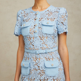 Model wearing Isola baby blue guipure lace mini dress with floral appliqué and belted waist