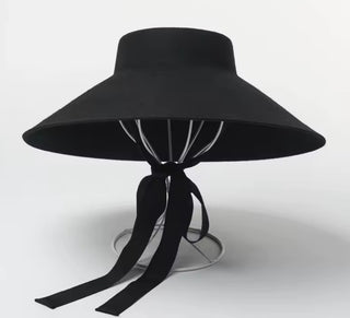 Black wide-brimmed hat with a ribbon on a white background