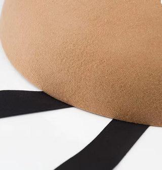 Close-up of a brown leather seat with a black strap on a white background