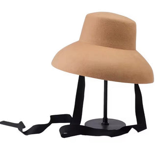 Tan hat on a black stand with a white background
