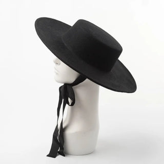 Black wide-brimmed hat on a mannequin head with a white background