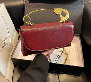 Red handbag with gold handle held over a box labeled 'Ninety Percent'.