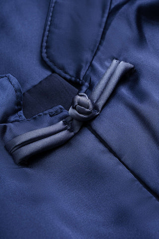 Close-up detail of a dark navy blue garment featuring a traditional Chinese-style front placket and a fabric tie closure.