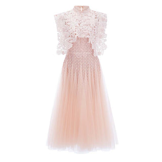 A sleeveless high-neck tulle dress in a soft blush pink, featuring a sheer floral lace overlay on the bodice and cap sleeves, with a full layered tulle skirt.