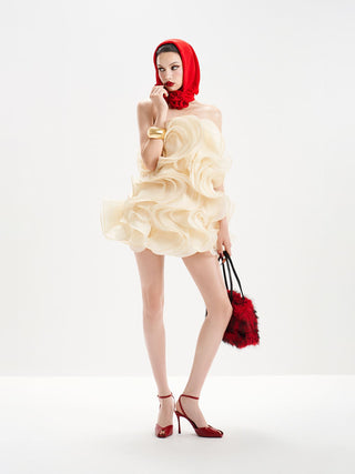 Woman wearing a white dress with ruffles, red headscarf, and high heels on a white background