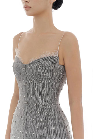 A close-up of a model wearing a gray and white herringbone-patterned dress with silver rhinestone embellishments and thin beige lace underwire cups.