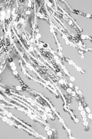 Silver and white sequin strands on a gray background