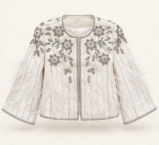 An off-white cropped jacket featuring intricate silver beadwork, sequins, and feathered fringe on the sleeves, set against a solid cream background.
