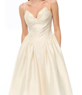 An ivory A-line dress with a sweetheart neckline, structured corset bodice, and thin spaghetti straps, shown on a model against a white background.