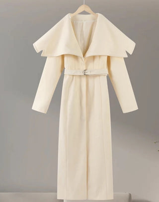 Beige trench coat on a hanger against a gray background