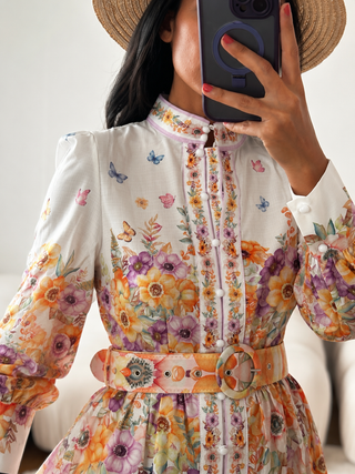 Elegant floral mini dress featuring a romantic watercolor flower print in pink, peach, lavender, and yellow tones, long sleeves, high neckline, matching waist belt, fit and flare silhouette, and feminine spring-inspired design, perfect for wedding guests, baby showers, bridal showers, garden parties, brunches, vacations, and summer occasions. Zimmermann Style Dress inspired dupe alike 