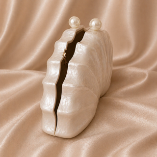 Pearl clutch bag on a beige fabric background