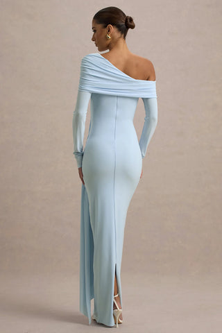 Woman wearing a light blue off-shoulder gown with a slit on a beige background