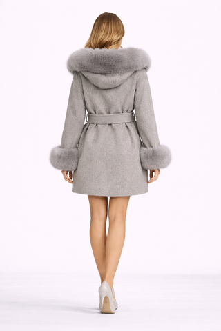Woman wearing a gray coat with fur trim on a white background