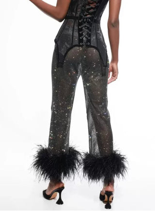 Black sequin jumpsuit with feathered cuffs on a white background