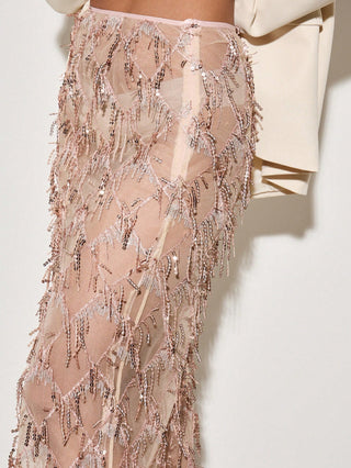Close-up of a sheer, embellished skirt with a neutral background