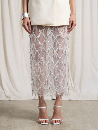 Person wearing a sheer, patterned skirt with a plain background