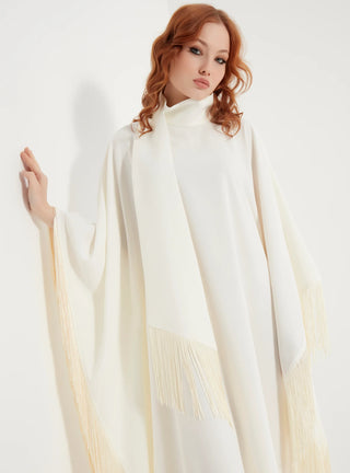 Woman wearing a white cape with long sleeves on a white background