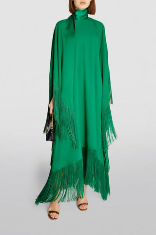 Green dress with fringe details on a plain background